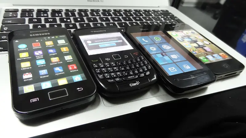 Un téléphone Samsung sous Android aligné en 2012 à côté d'un BlackBerry, d'un Windows Phone et d'un iPhone, du temps où Android affrontait encore plusieurs rivaux.