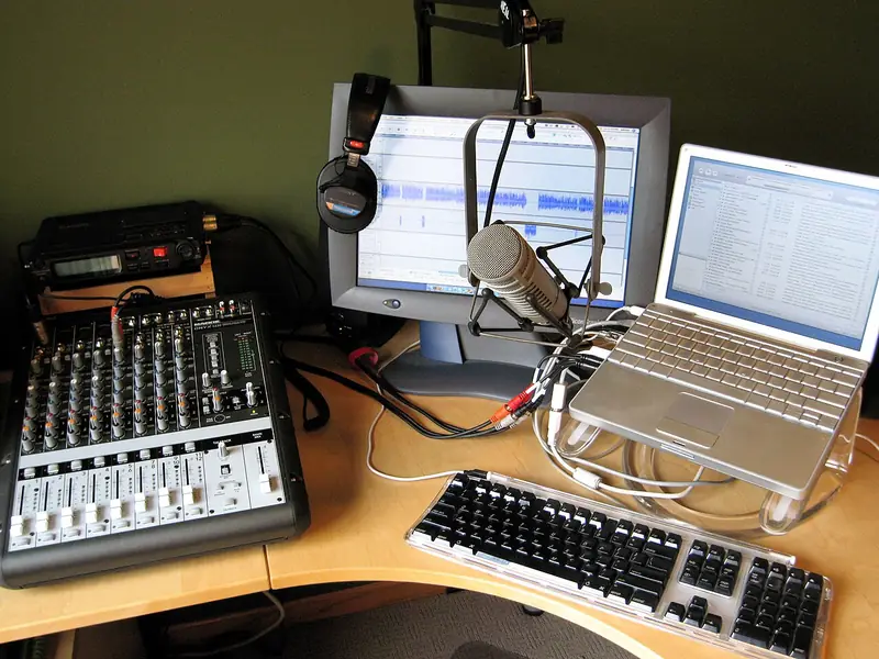 Un studio de podcast amateur aménagé à la maison en 2006, aux débuts du podcast : micro, table de mixage, enregistreur et ordinateurs.
