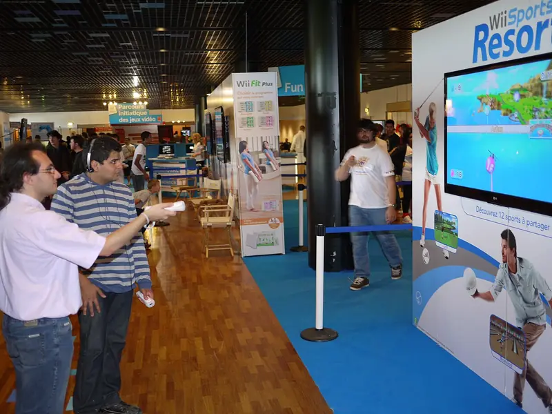 Des visiteurs jouent à Wii Sports Resort, télécommande Wii en main, au salon Montpellier in Game en 2010.