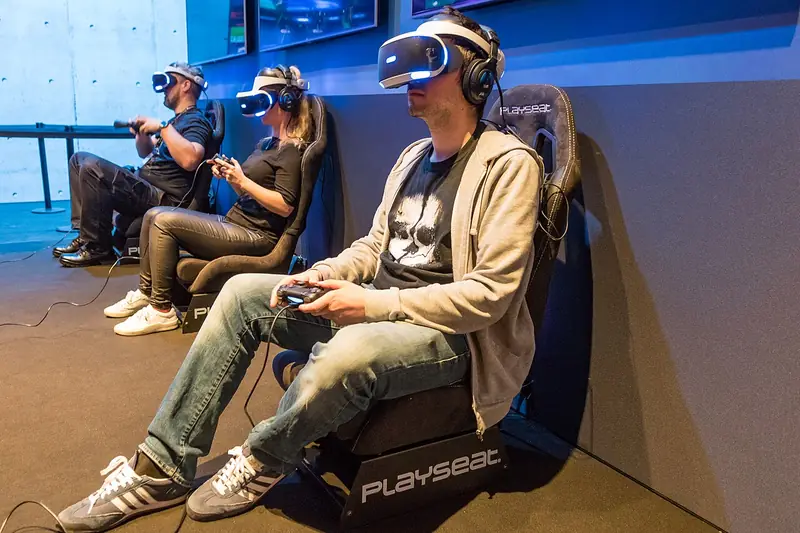 Des joueurs essaient le PlayStation VR dans des sièges de course à la Gamescom 2017.